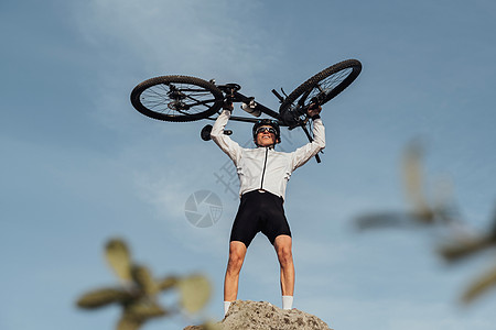 职业男性赛事名单 在站在山顶 天空在背景上时 用自行车举起手来男人运动冒险车轮速度运动员运输闲暇骑士竞赛图片