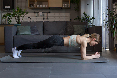 一位中年妇女在家从事健身和运动锻炼身体训练冥想重量运动服肌肉女性成人体操房间图片