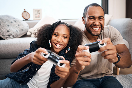 爸爸养大了一个真正的赢家 一个年轻女孩在家和父亲玩电子游戏呢图片