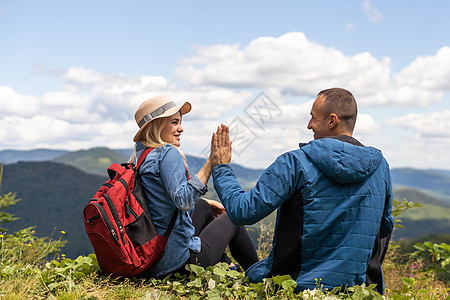 情侣旅行者男人和女人坐在放松的山上 观看爱情和旅行快乐的情感生活方式概念 旅行活跃冒险假期的年轻家庭山脉远足自由女性娱乐情怀游客图片