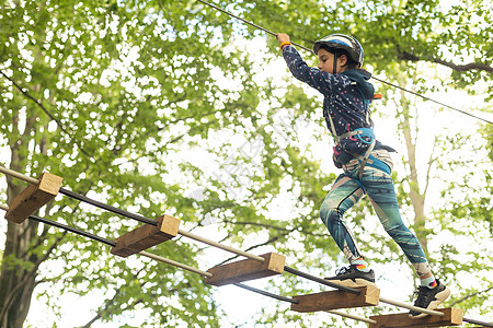 冒险攀登高空钢丝公园  儿童课程绳索公园 绳索公园绳索桥上可爱小女孩的画像平衡乐趣喜悦行动学校活动挑战安全木头闲暇图片