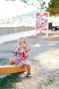 小女孩坐在操场的泰特托塔上图片