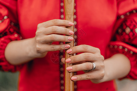 女人在户外演奏木管乐器木笛-乌克兰 sopilka 民间音乐概念 乐器 身穿传统刺绣衬衫的女士 - 红色 Vyshyvanka图片
