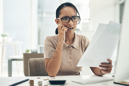 糟糕的预算会导致更多的财务压力 一位年轻的女商务人士在办公室计算财务时看起来压力很大图片