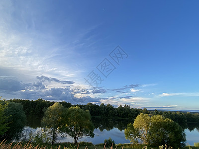 湖边美丽的夕阳 日落在水中反射   蓝色和橙色的天空 云彩和树上环绕着月光晴天假期地平线夫妻森林橙子女孩太阳旅行阳光图片