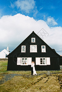 新娘和新郎拥抱 在黑木屋附近 冰岛图片
