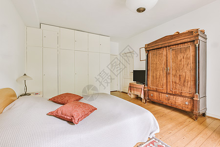 现代衣柜带木制衣柜的轻型卧室住宿家庭白色公寓窗户木地板家具房子组织住宅背景