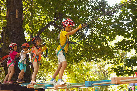 孩子们在悬吊桥上爬上去了闲暇力量木头头盔女孩冒险勇气风险童年森林图片
