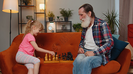 微笑的老爷爷玩棋盘游戏 在家和十几岁的孙女女女儿孩子一起玩两个人竞赛孙女战略教育享受乐趣童年青春期闲暇图片