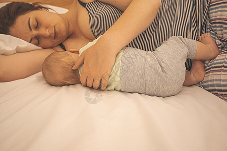 母亲和新生儿睡在床上睡觉家庭男生吮吸孩子父母妈妈儿子睡眠护理母性图片
