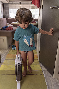 可爱勤奋的婴儿用吸尘器清洗大篷车打扫儿子房间无所事事妈妈跳跃男人家庭命令快乐图片