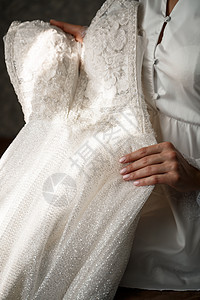新娘在婚礼当天手里拿着一件白色的礼服蕾丝裙子女性女孩夫妻男人女士手套指甲庆典图片