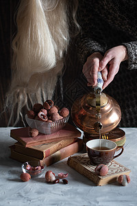 一个女人从铜茶壶里倒茶水 泡到杯子里 喝着莱奇和温柔的生活女性享受喝咖啡文化静物荔枝女士桌子注意力爱好图片