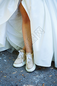 婚礼当天穿着白色礼服和运动鞋的新娘头发微笑成人女士婚姻太阳女性挑衅面纱卡通片图片