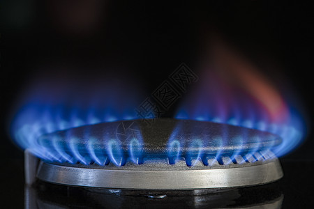 燃烧天然气 丙烷 在黑色背景上的煤气炉 带有蓝色火焰的燃气厨房炉灶的碎片 特写 能源危机概念 价格上涨或天然气价格上涨危险炊具烹图片