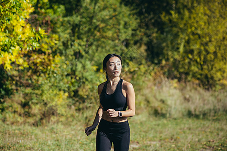 早上在公园跑步的美丽亚洲女人 一个穿着深色运动服的女人运动踪迹健康女性慢跑女士活力太阳微笑训练图片