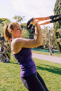 培养有健身带的强壮女子二头肌带子女孩运动装肌肉耐力活动公园运动培训师力量图片