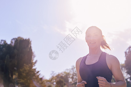 一名在公园跑的女运动员肖像活动赛跑者慢跑晴天慢跑者重量闲暇女孩女士女性图片