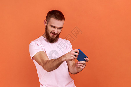 人站着 使用智能手机 和玩移动游戏 用皱眉脸背景图片