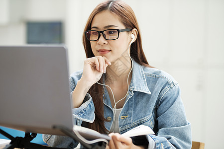 年轻女性在家笔记本电脑前学习 在计算机前学习在线会议工作隔离阅读互联网大学技术课程培训图片