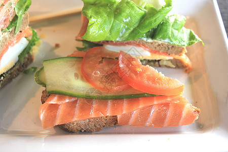 新鲜的三文鱼三明治 熏鲑鱼 生菜 鲜瓜和鸡蛋食物午餐草本植物烟熏海鲜鱼片小麦餐厅面包绿色图片
