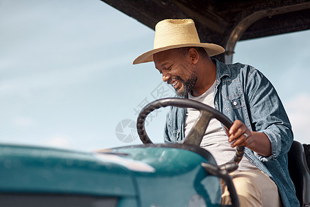 是个成熟男人驾驶拖拉机在农场里开着拖拉机图片