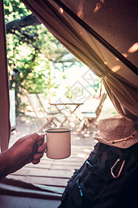 一个在露营帐篷里拿着杯子的人的手游客背包休息手臂旅游成人娱乐假期风景男性背景图片