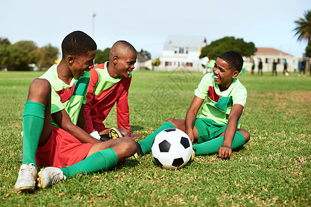 一群男孩在运动场上打足球时休息一阵子 在球场上玩得总是很开心图片