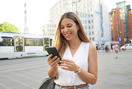 令人惊讶的商业女性在市街的手机路上观看和发短信 这让人吃惊图片