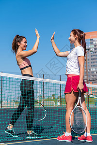 在户外法庭参加网球比赛前 两名穿运动服的高加索妇女打招呼 玩家们在比赛前击掌5次行动训练朋友们运动幸福祝贺团队夫妻活动快乐图片