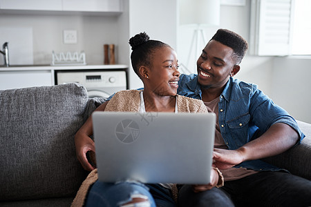 下一集 一对年轻夫妇在家里沙发上用笔记本电脑图片