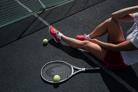一个穿着运动裙的无脸女孩坐在网球场上 拿着一枚火箭 对女性腿最有洞察力体育锻炼阴影裙子竞赛阳光练习锻炼晴天球拍网球图片
