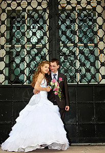 年轻结婚夫妇站在大门口附近图片