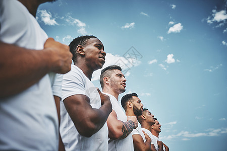 尽情歌唱 在橄榄球比赛前 一群自信的年轻橄榄球运动员在场外立正唱着他们的国歌背景图片