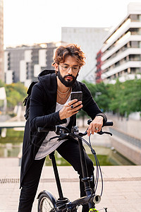 男子在骑自行车时使用手机;男图片