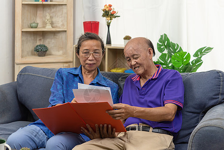 在沙发上签订退休保险保健合同 说幸福的老年夫妇在谈婚论嫁投资家庭男性微笑成功女士夫妻代理人客户生活图片