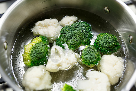 花椰菜和花椰菜在煤气炉子上的灰色酱锅里沸腾火炉食物菜花平底锅成人菜肴饮食食品妈妈滚刀图片