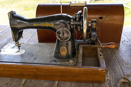 古旧黑缝纫机和储藏用的硬木干箱图片