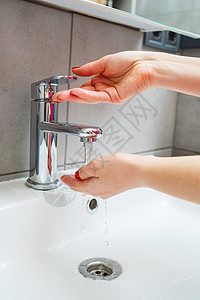 浴室里有一个银色水龙头的白色水槽 灰色罐装洗手液 打开自来水 个人手卫生 在流水下洗手陶瓷制品肥皂卫生间整洁细菌龙头温泉清洁度合图片