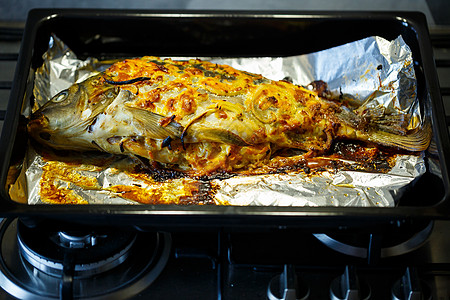 有洋葱和奶酪的烤鱼饮食筹码烹饪鱼片柠檬脆皮鳟鱼蔬菜香菜胡椒图片