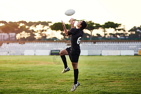 快速反应是必不可少的 一个英俊的年轻运动员在白天的训练课上打橄榄球的全长镜头图片