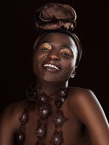 非洲服饰通过她的笑容展现她的美丽 画室画像 一位身着非洲传统服饰的迷人年轻女子在黑色背景下摆姿势背景