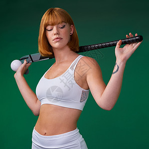一位有魅力的年轻女运动员站在绿色工作室的背景下 冒充着曲棍球装备 穿着曲棍球服图片