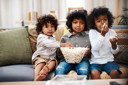 三个可爱的小男孩一起吃爆米花 在家一起看电影 好吗? (笑声)图片