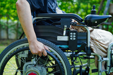 亚洲老年妇女残疾病人坐在公园的电动轮椅上 医疗概念 207年护士卫生机动性微笑男人帮助旅行车轮退休摩托车图片