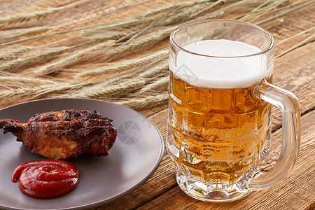 一杯啤酒 盘子加烤鸡和大麦耳朵 在木制背景液体小麦啤酒厂酿造白色泡沫黄色饮料玻璃桌子图片