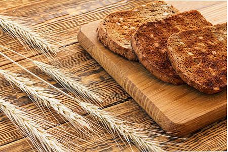 木制切割板和木制板上小麦干小点子的吐司耳朵小穗稻草农场生产产品面包粮食收成木头图片
