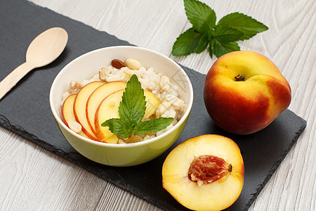 石板上有坚果和新鲜桃子的高梁沙拉石头谷物香料腰果粮食水果杏仁植物稀饭食物图片
