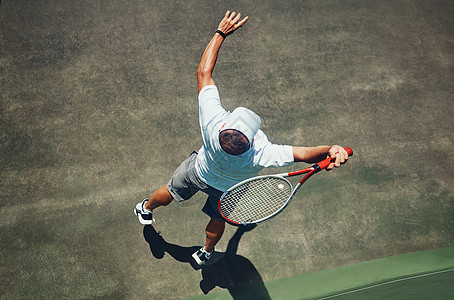 我赢了这盘 白天 一个专注的中年男子在网球场外打网球的高角度拍摄图片