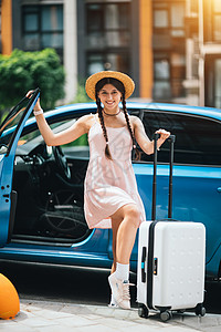 在户外出租汽车附近携带手提箱旅行的妇女车辆女士运输顾客司机汽车女性服务行李经销商图片